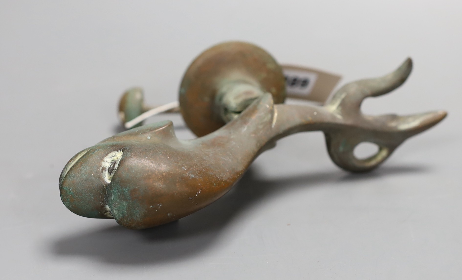 A Victorian cast bronze Dolphin door knocker, 21cms long.